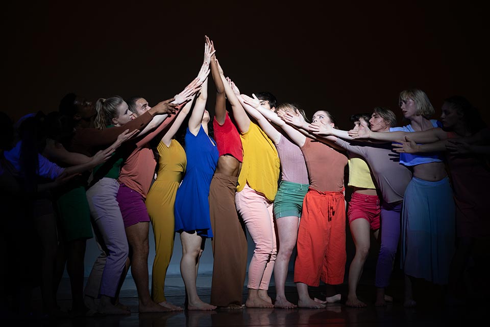 Dancers reaching together toward the sky