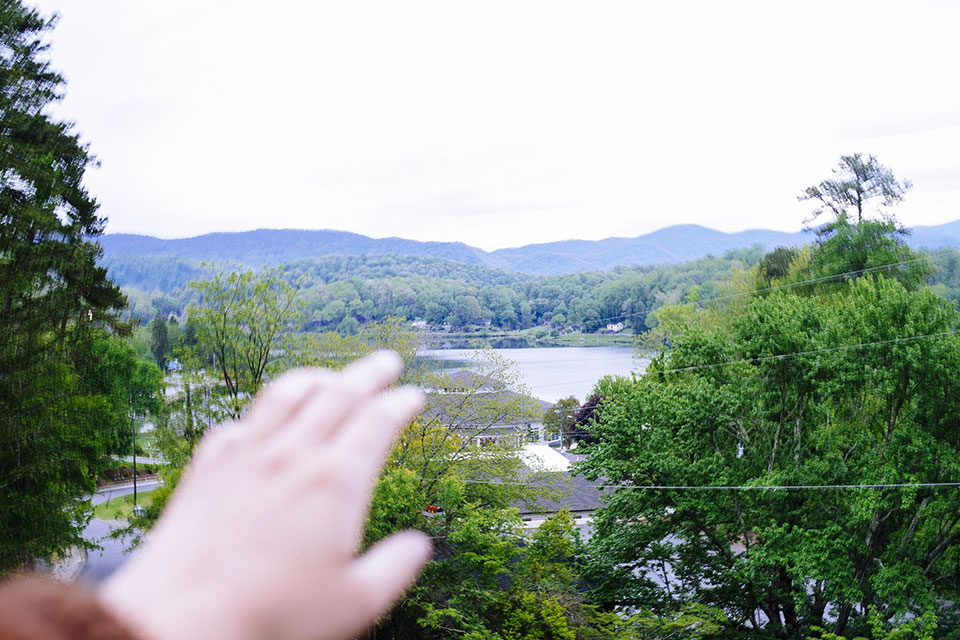 Hand reaching toward mountain skyline