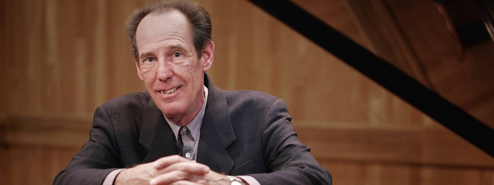 Emeritus Piano Faculty Member Eric Larsen seated at an open grand piano
