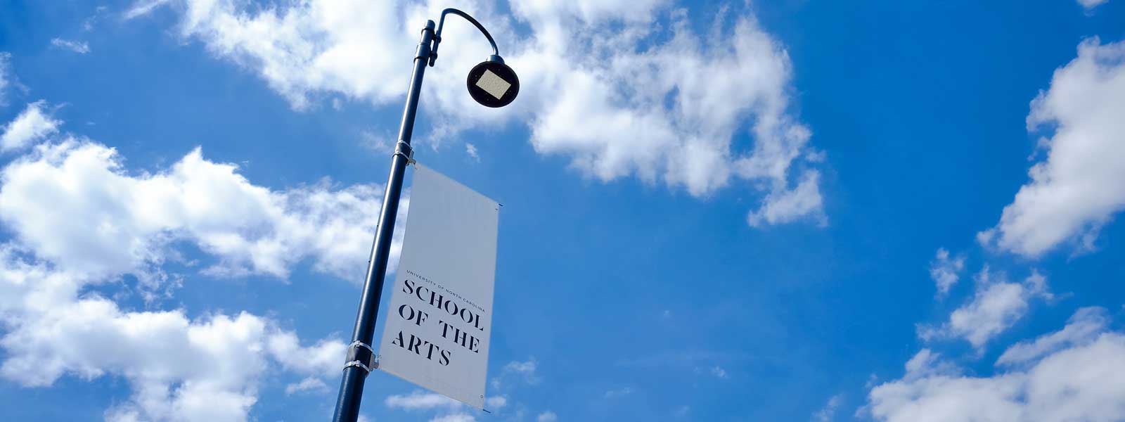 UNCSA banner against blue sky with clouds