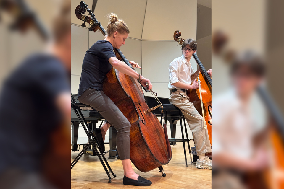 Two people seated and practicing musical instruments.